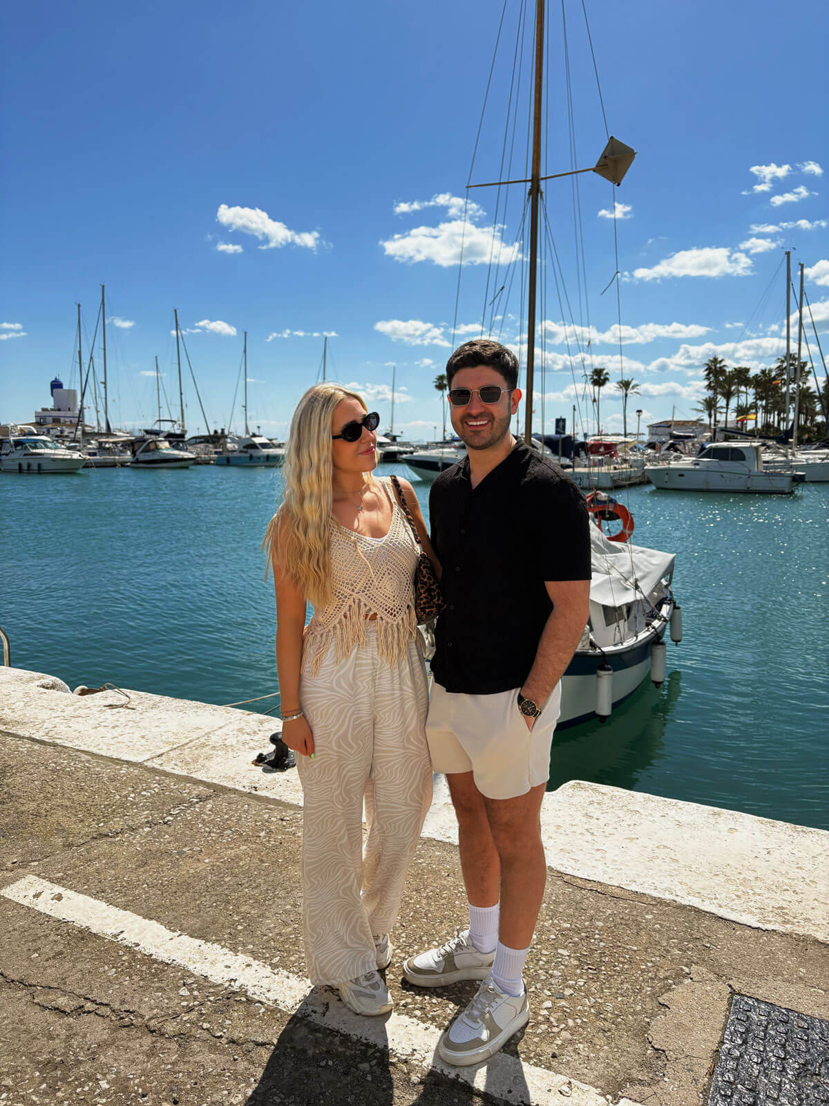 couple smiling at camera in marina