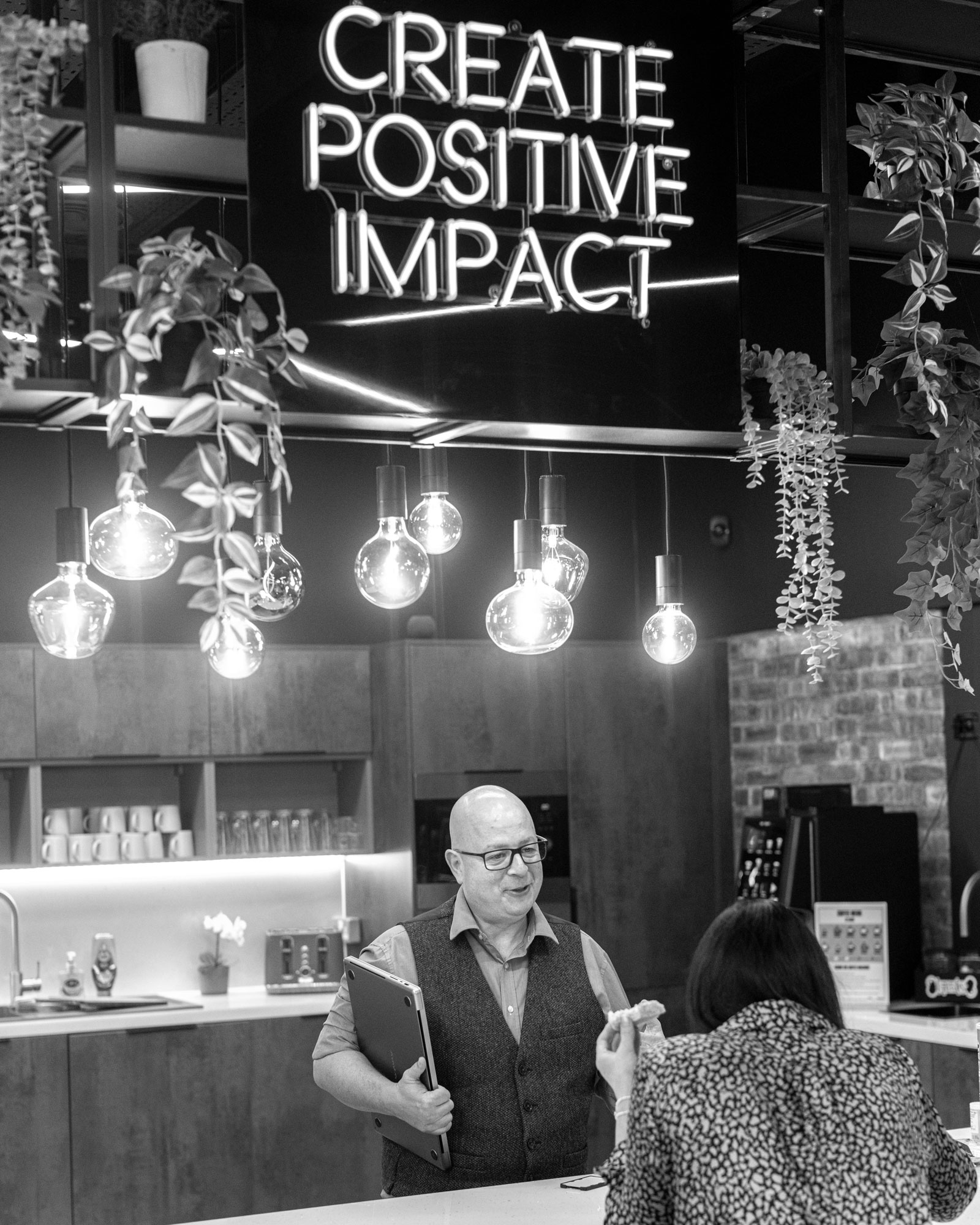 A man and a woman are speaking in a kitchen