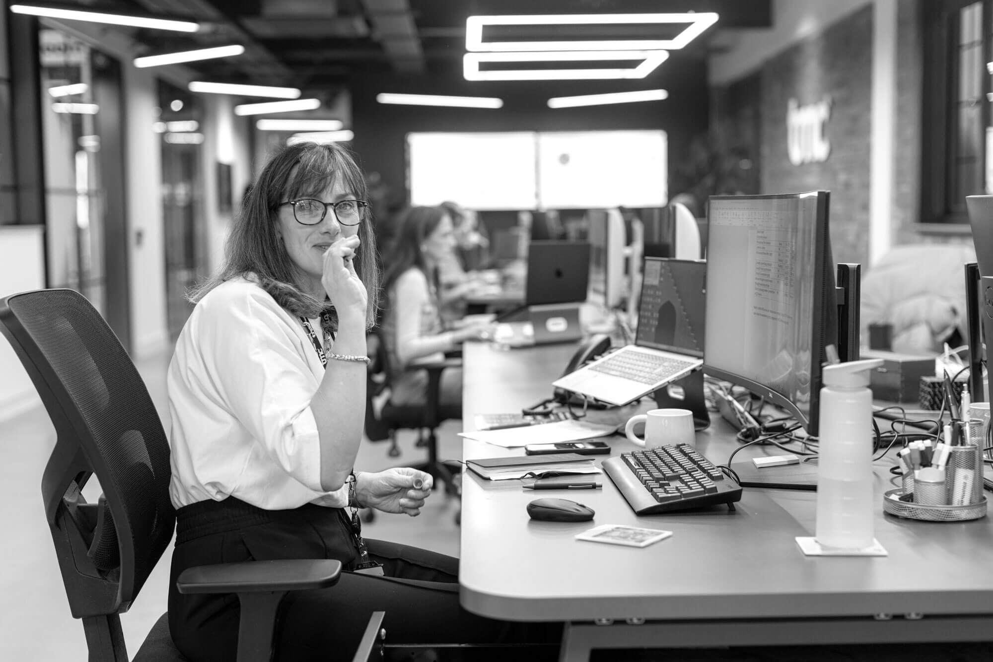karoline sat at her desk, smiling to camera